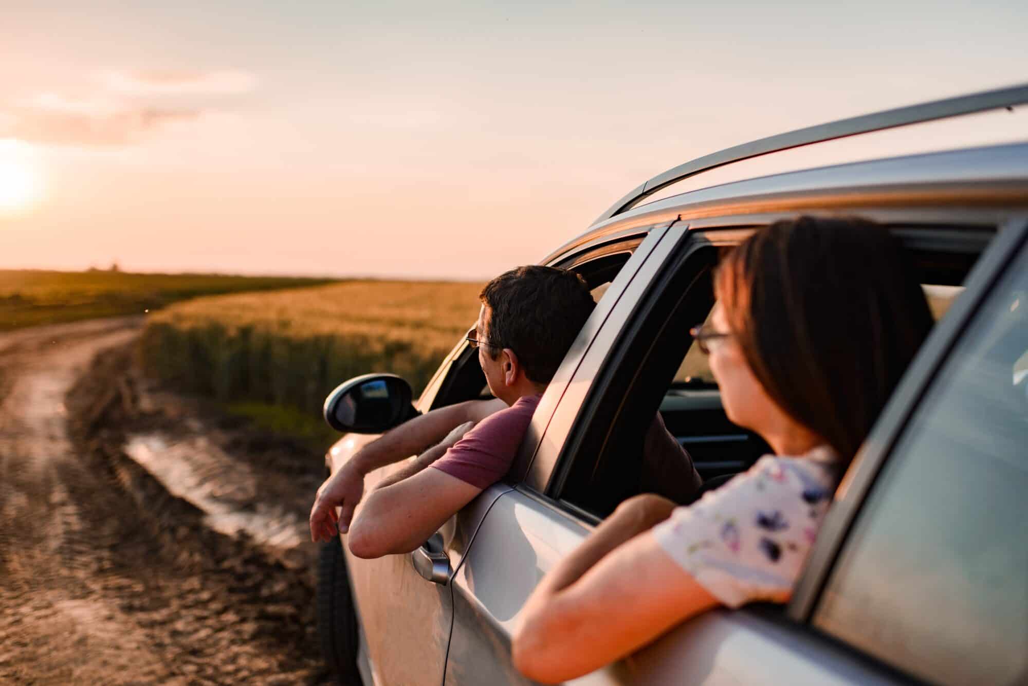 Beautiful senior couple enjoying on a road trip on sunset.