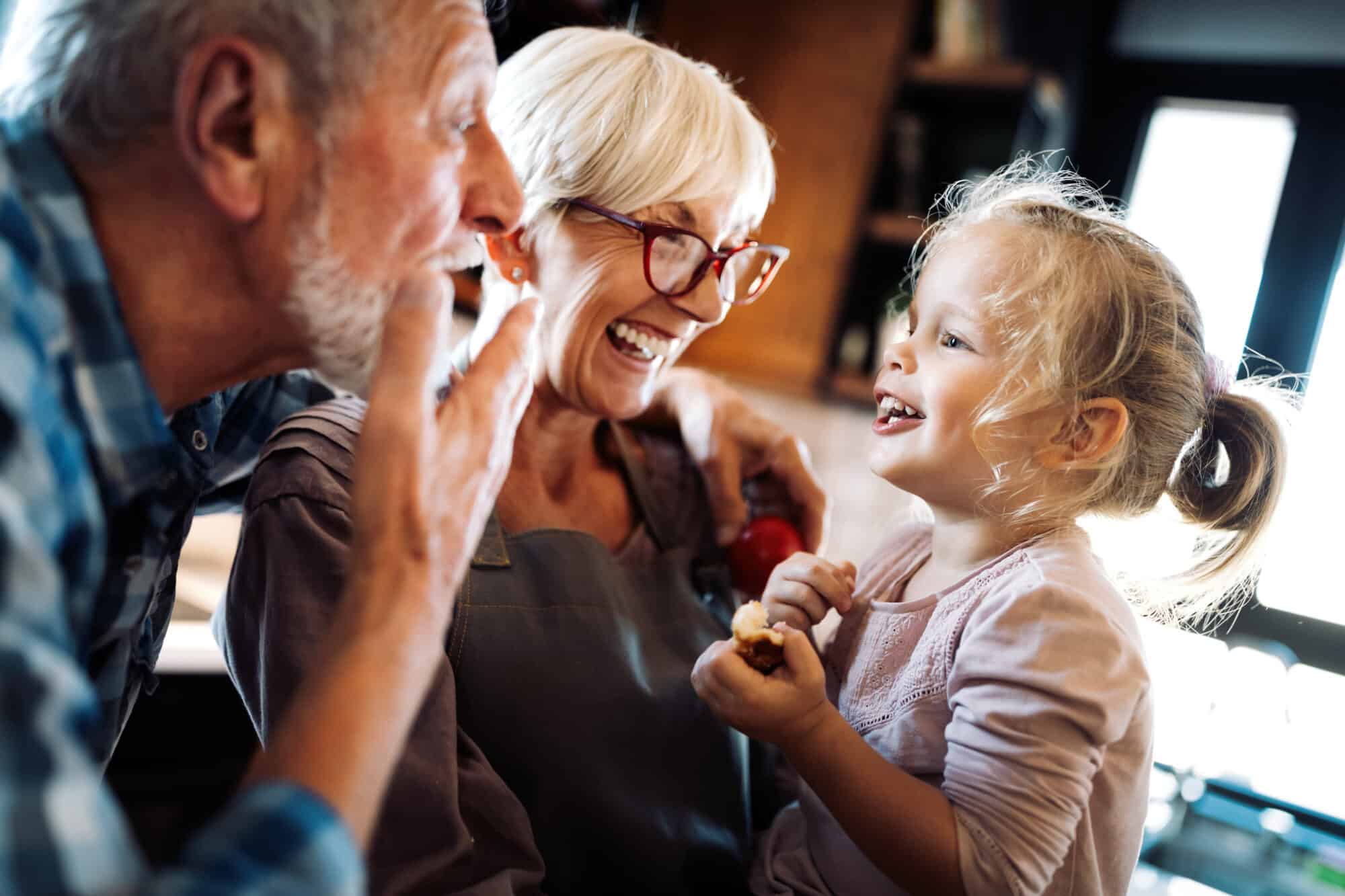 Grandparents playing with their grandchild as they consider child pension contributions